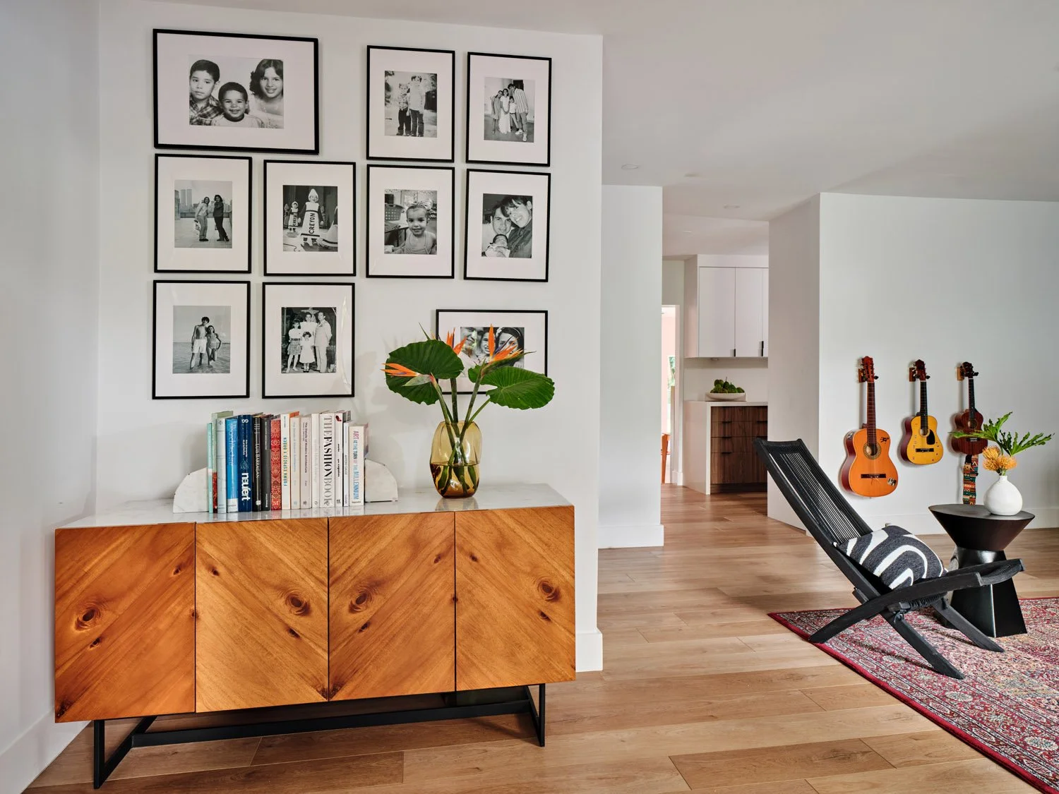 Walnut sideboard with framed black and white photos and guitars