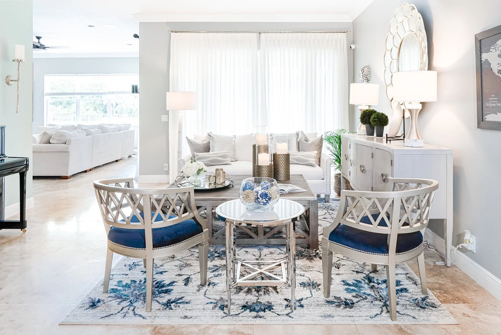 Dining and living area with blue cushioned chairs and patterned rug