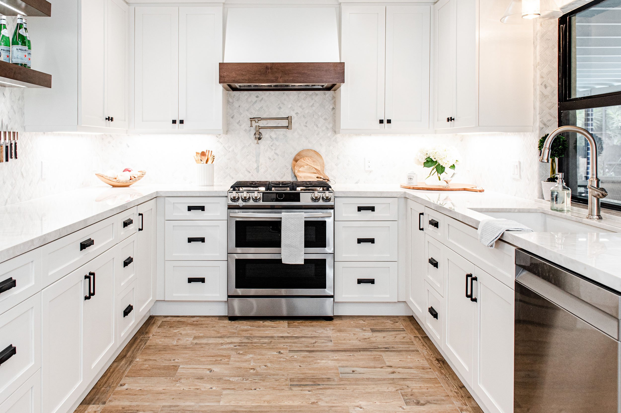 White U-shaped kitchen with stainless range and patterned runner
