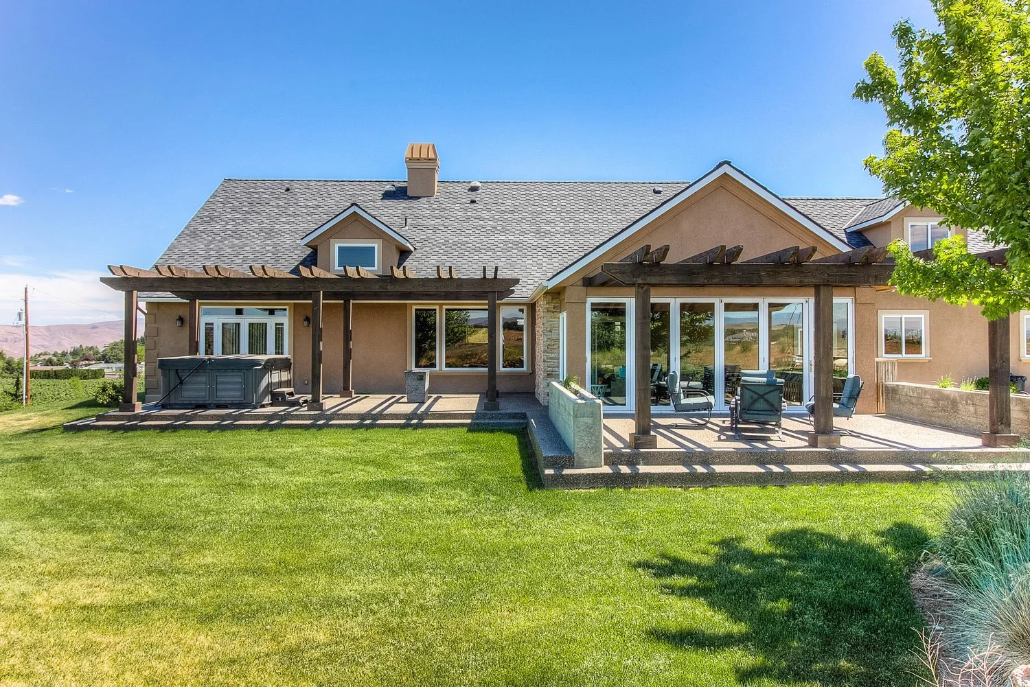 Rear exterior of home with sunroom, patio and lawn