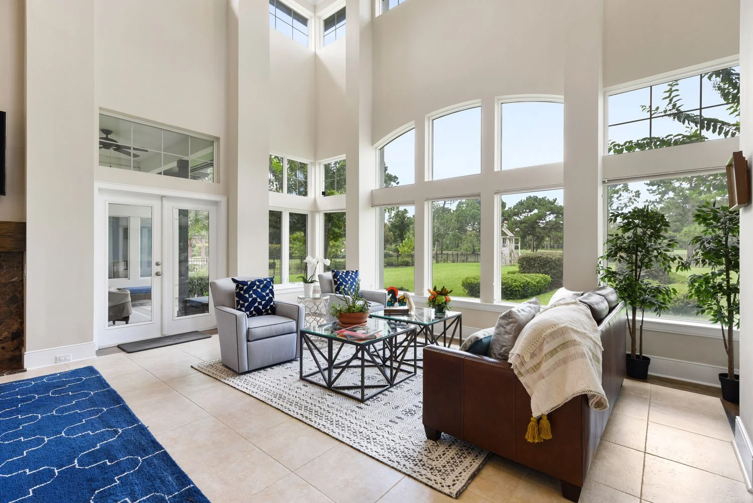 Two-story windows with leather sofa and navy rug