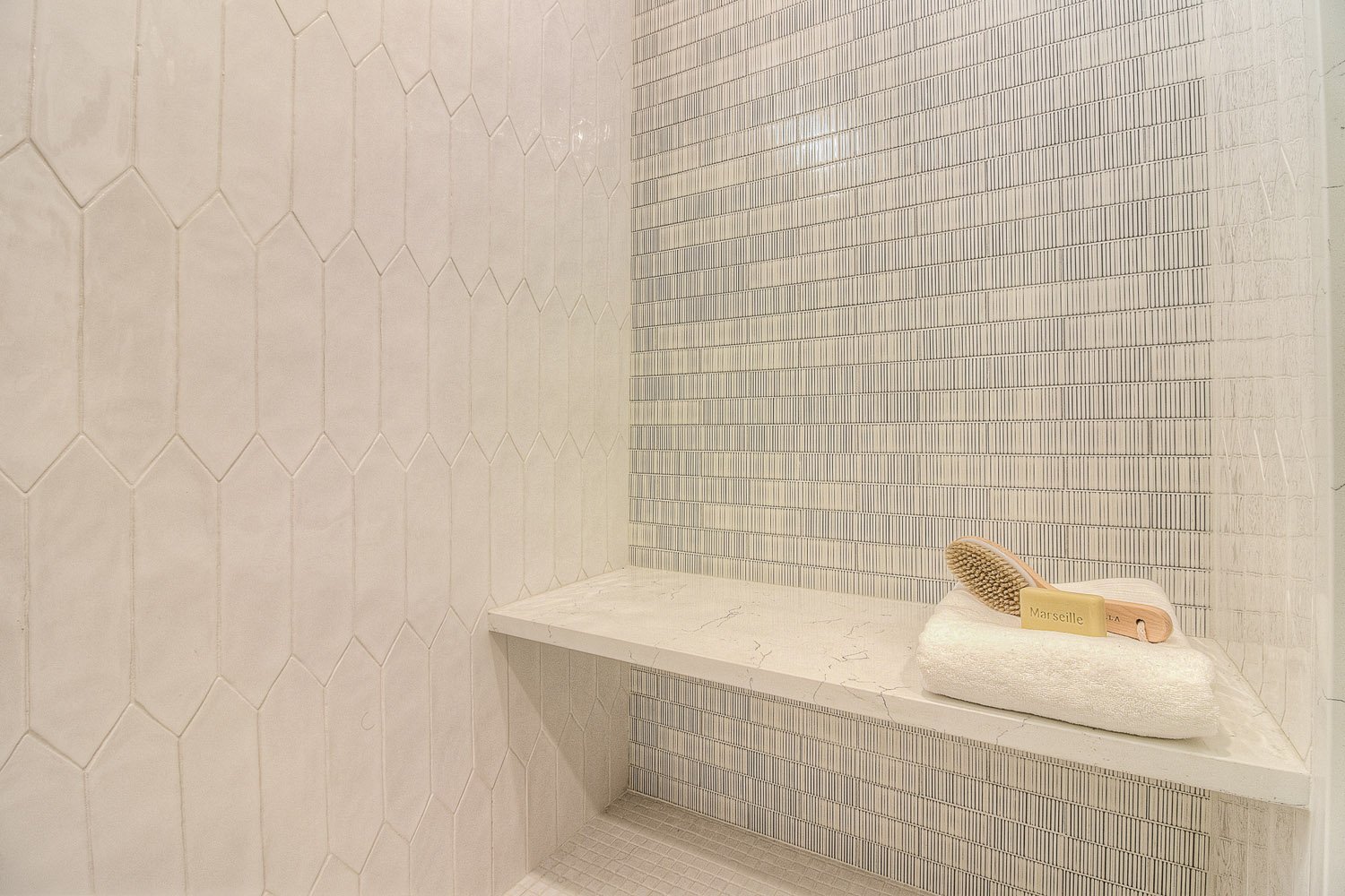 Shower niche with mosaic tile and marble bench