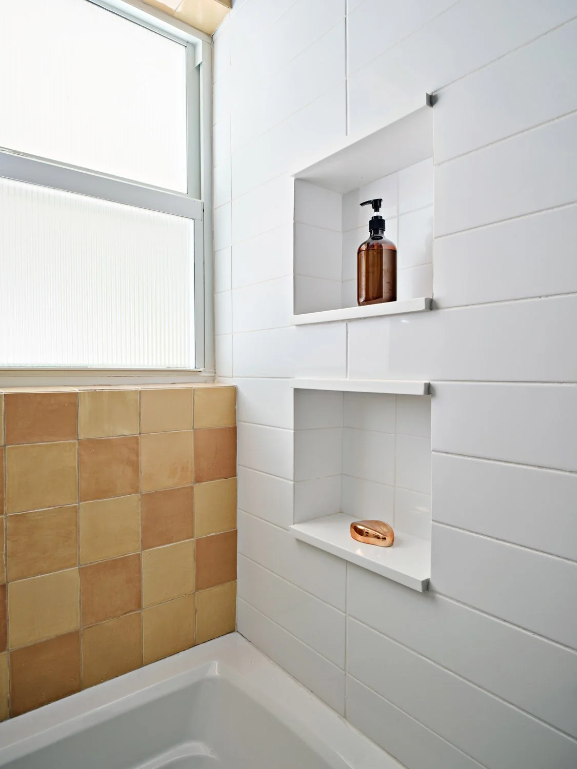Shower niche with yellow tile and white wall tile