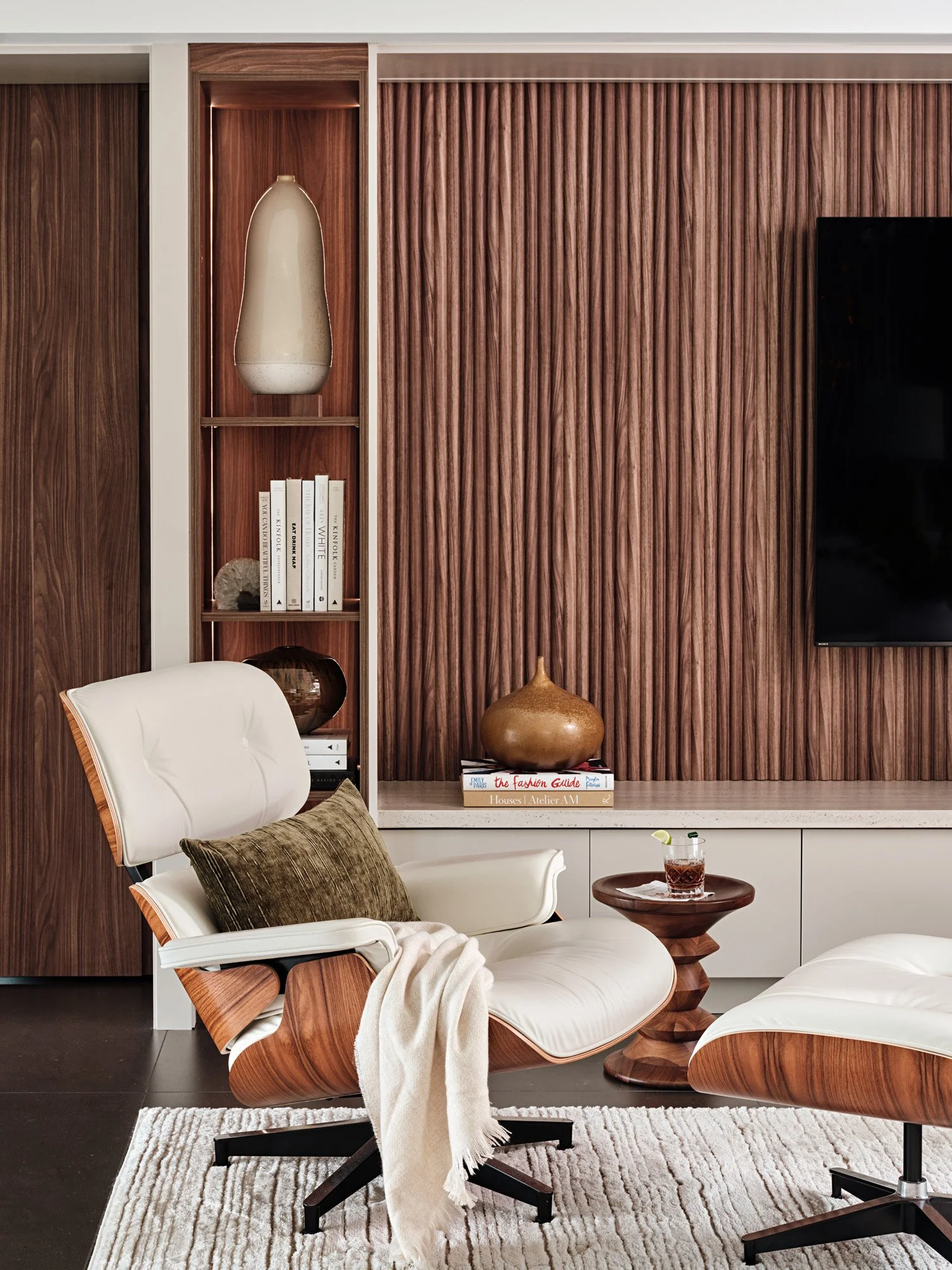 Custom walnut wall unit with niches, TV and leather lounge chair