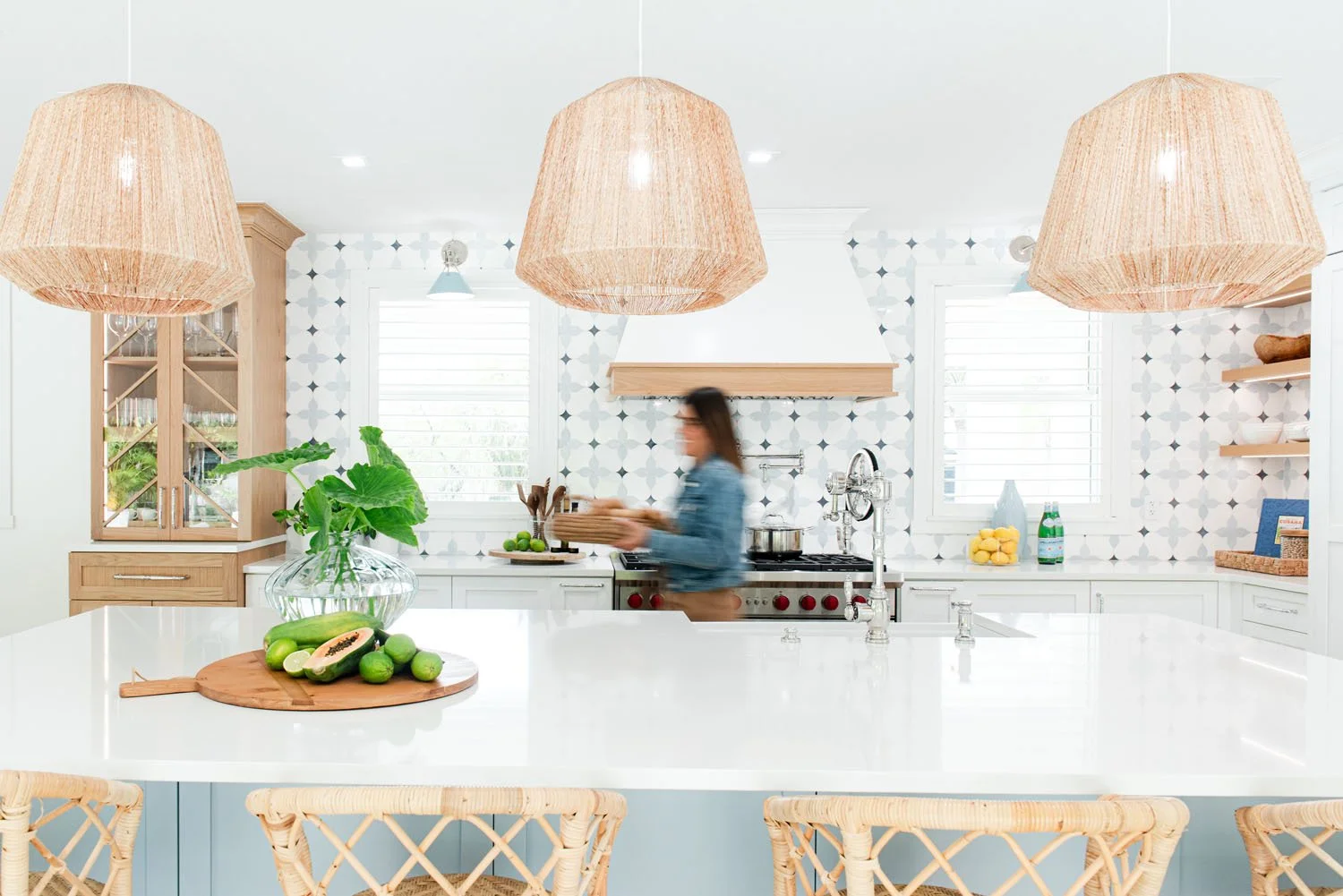 Interior designer Adriana Jacir at a kitchen island with rattan pendants