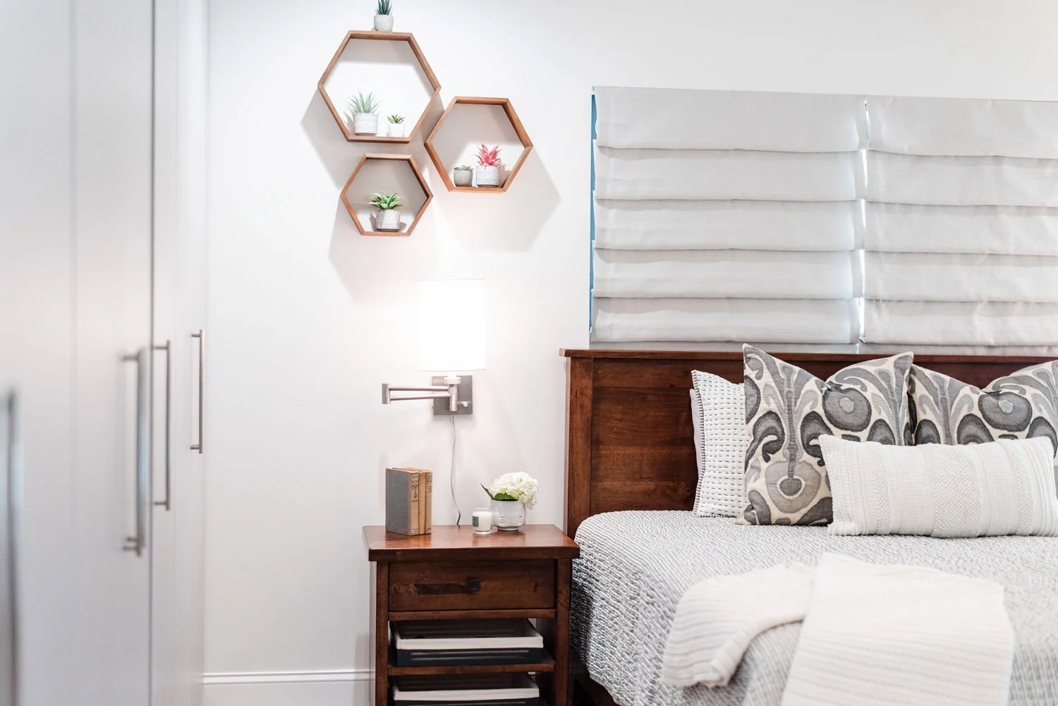 Bedroom with upholstered headboard panels and hexagon wall shelves