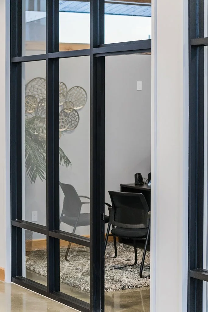 Black steel-framed glass door to a conference room
