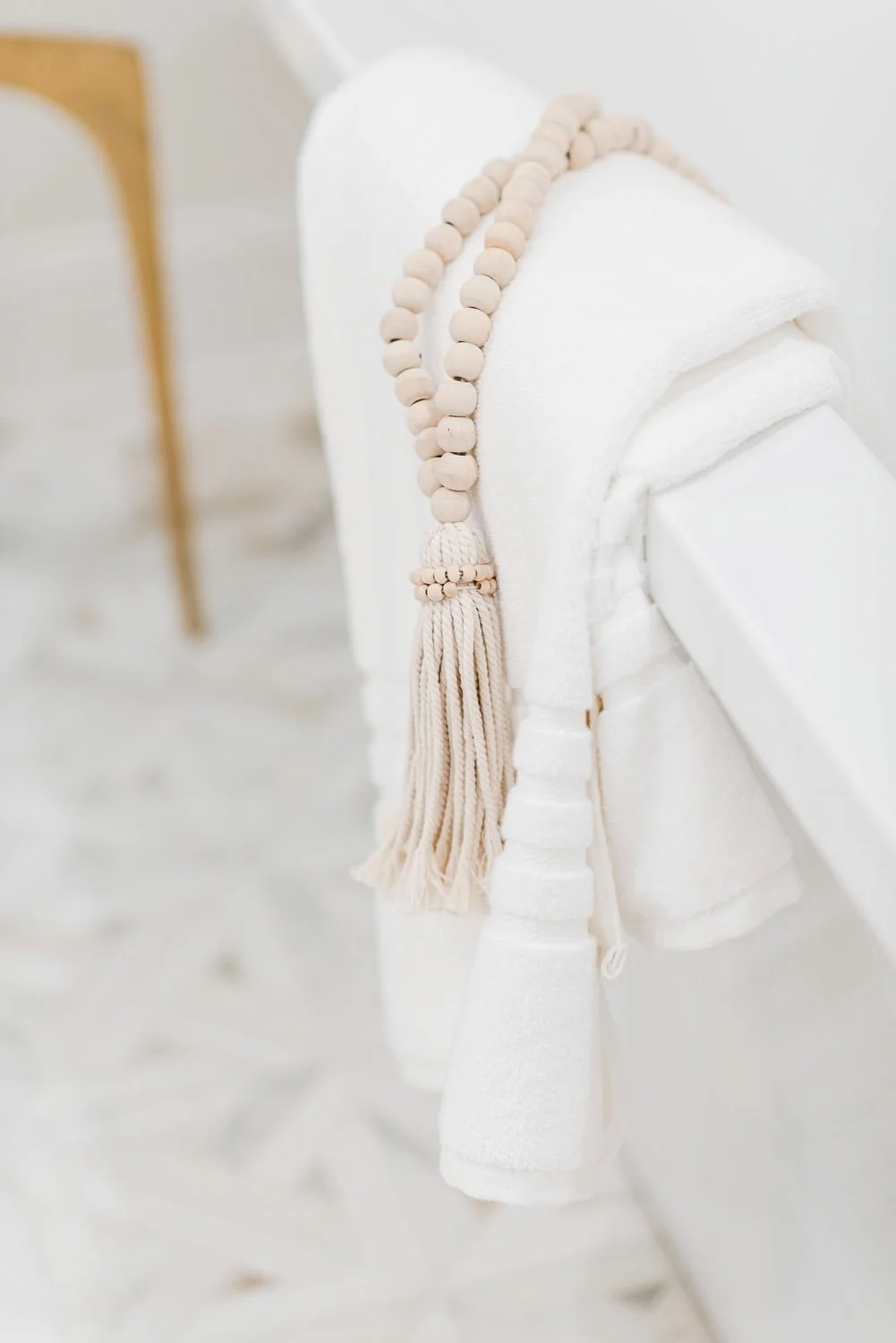 White towel with tassel trim draped on a freestanding tub