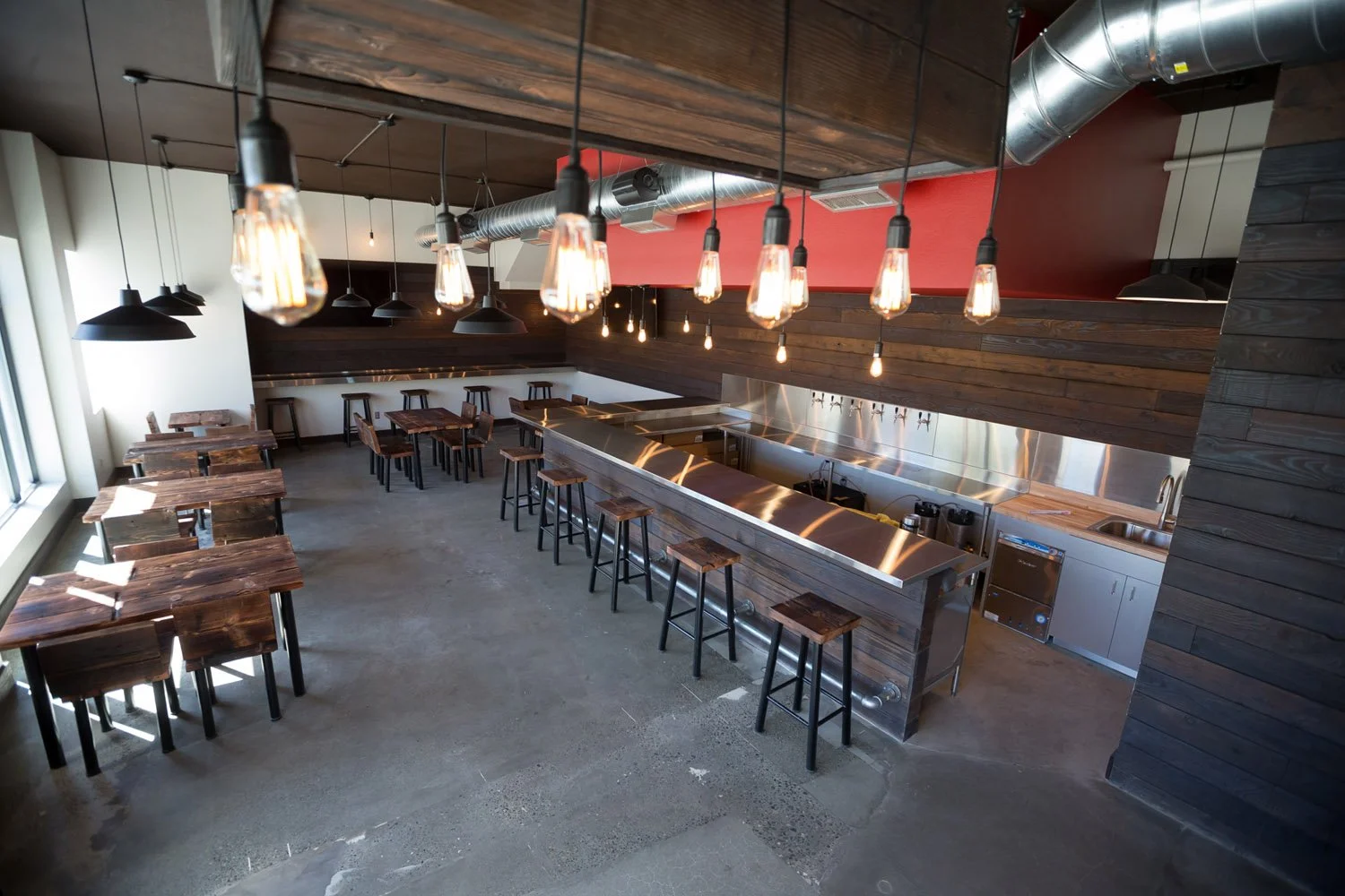 Taproom with bar, tables and exposed ductwork