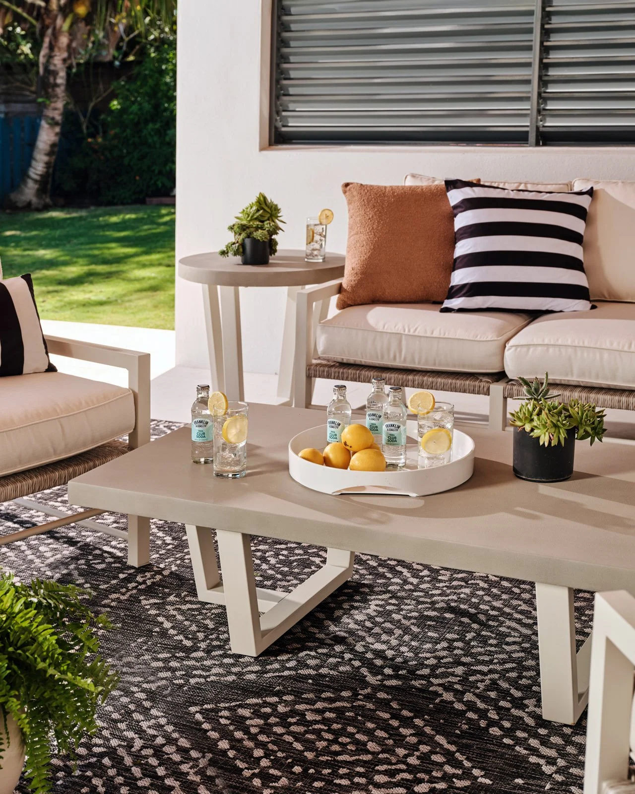 Outdoor coffee table with fruit bowl and patterned rug