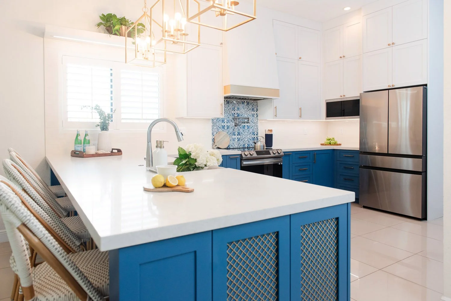 White and navy kitchen with large island and stainless refrigerator