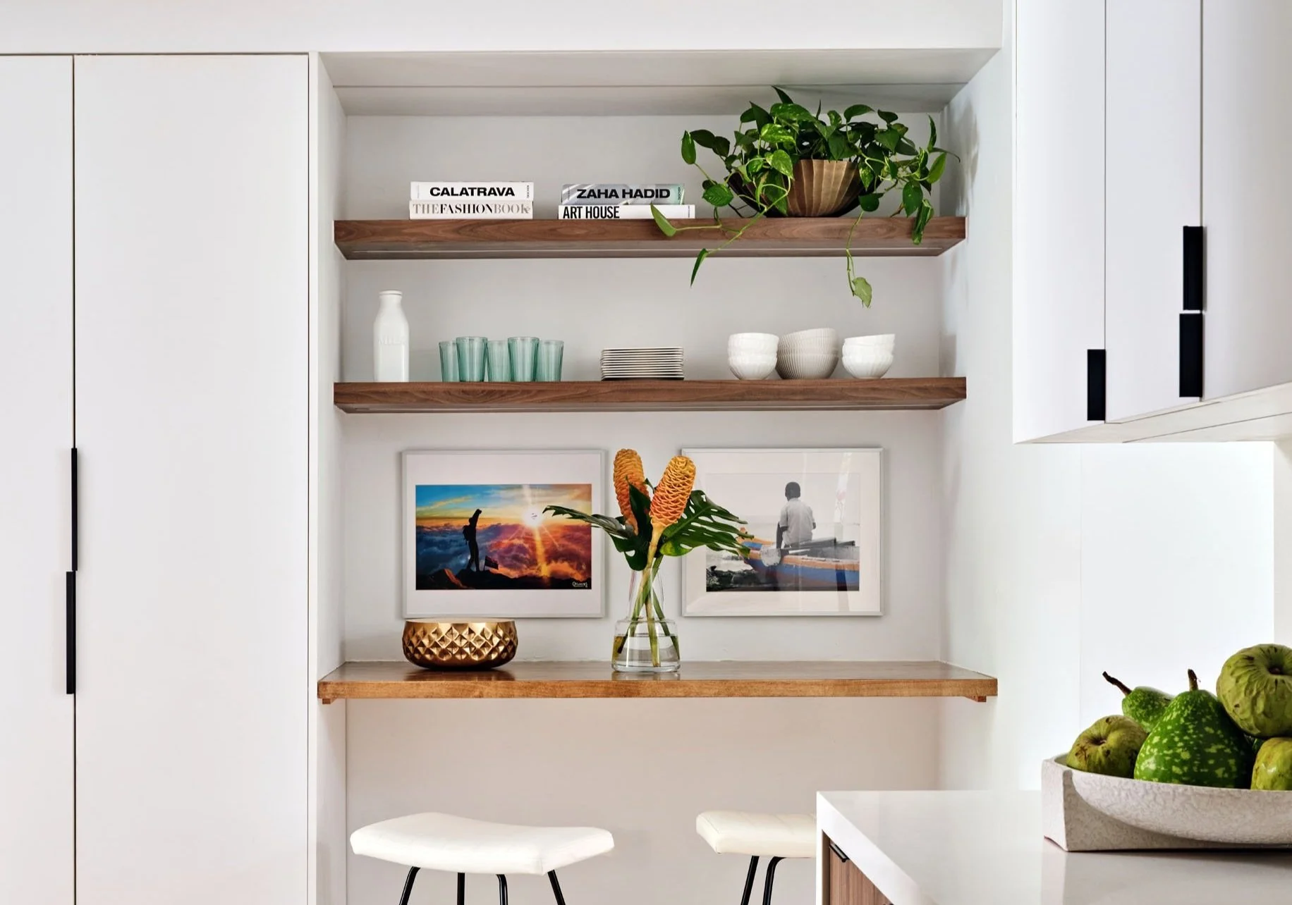 Floating wood shelves styled with plants, ceramics and framed art