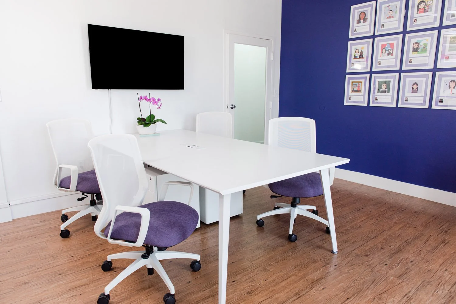 Office with white desk, purple chairs and navy accent wall