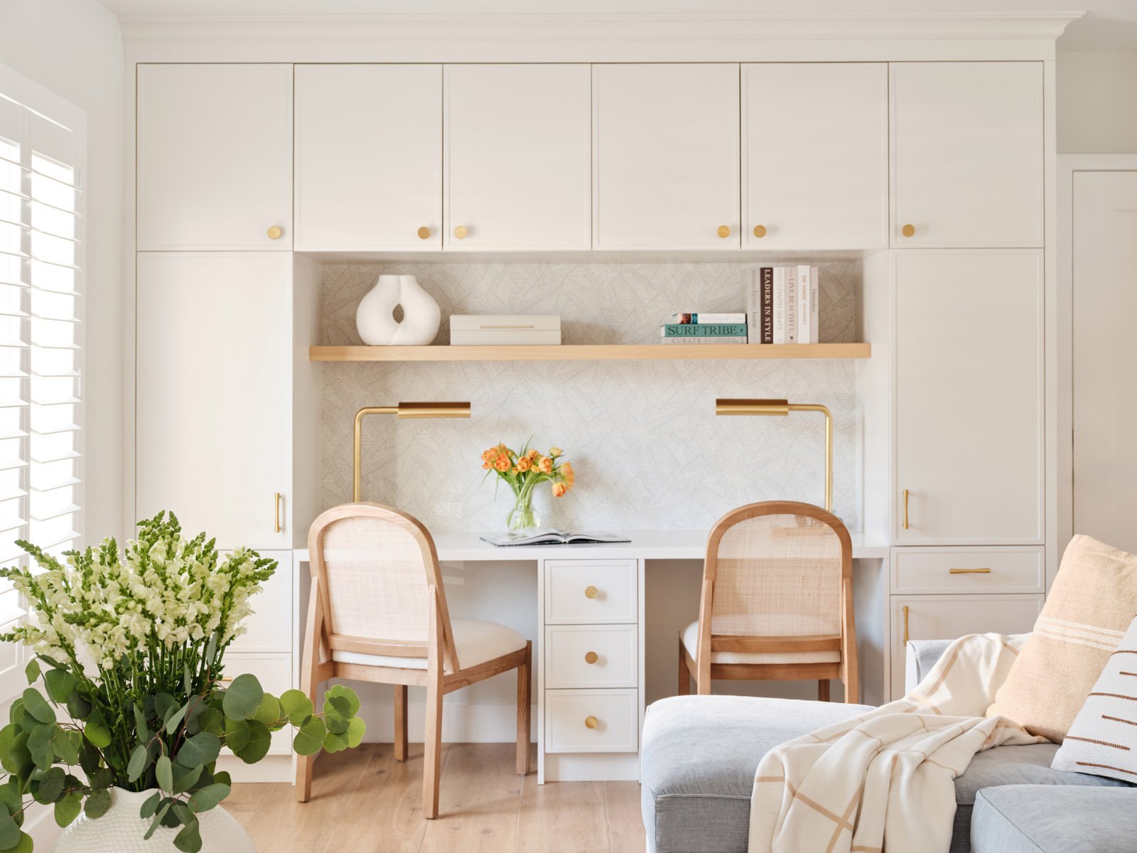 Built-in white cabinetry with desk nook and cane-back chairs