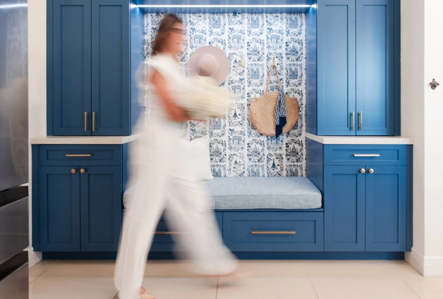 Woman walking past a navy built-in bench nook