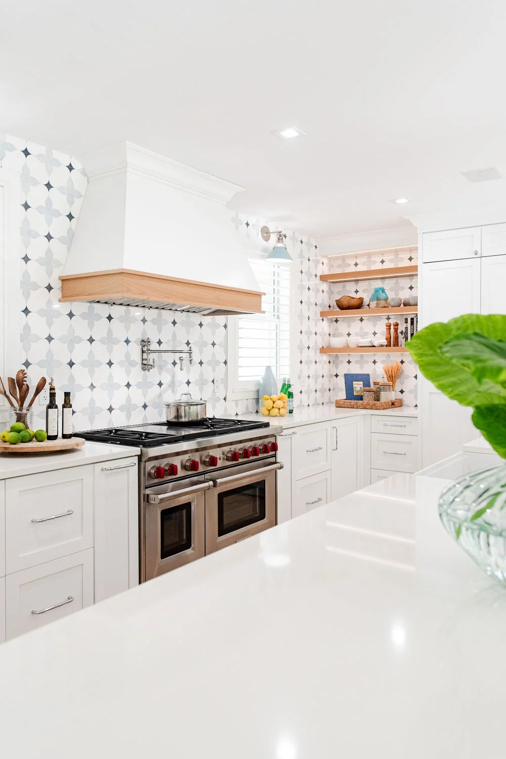 Professional range with wood shelf and patterned tile backsplash