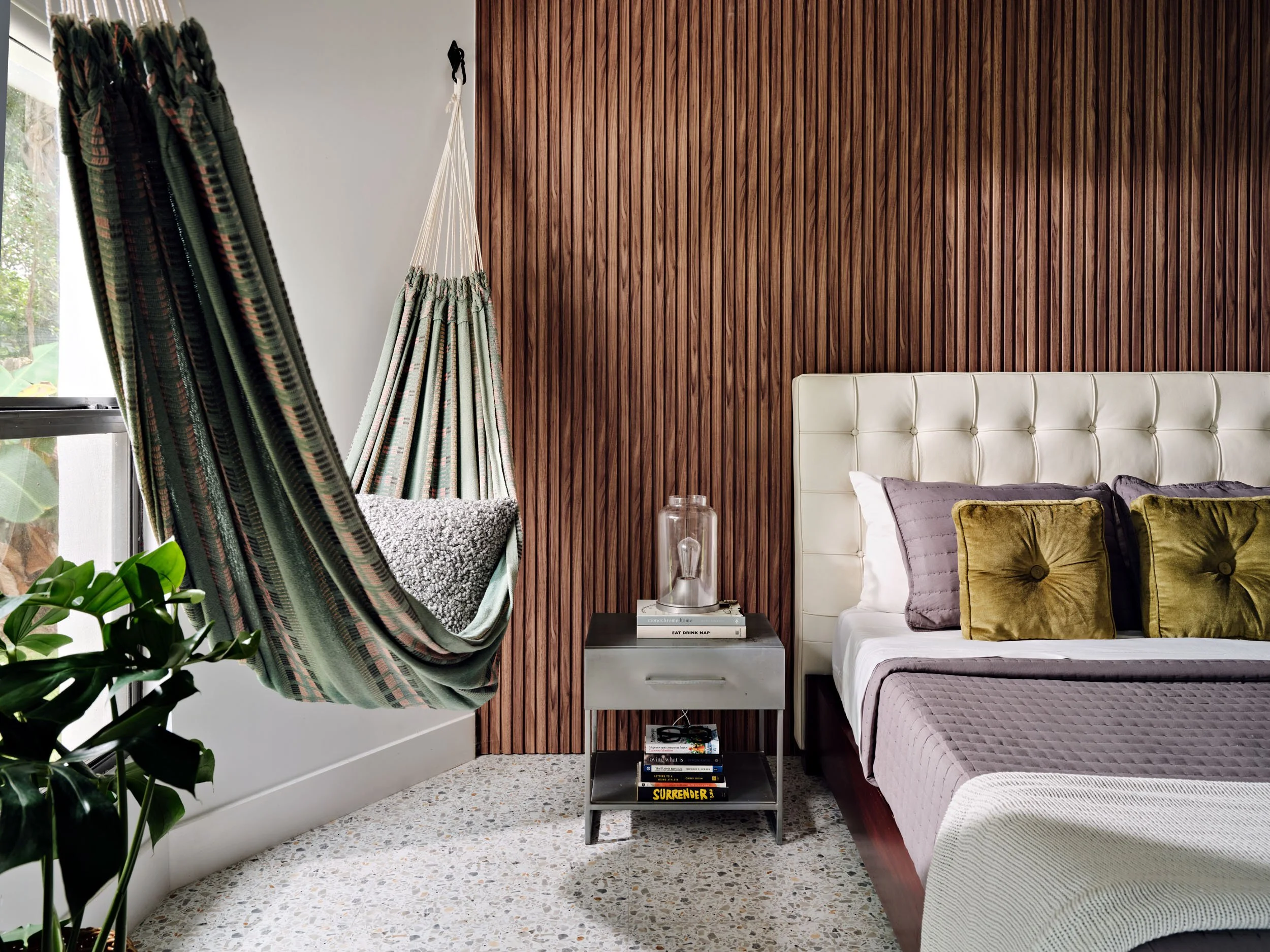 Bedroom with hanging hammock and wood slat accent wall