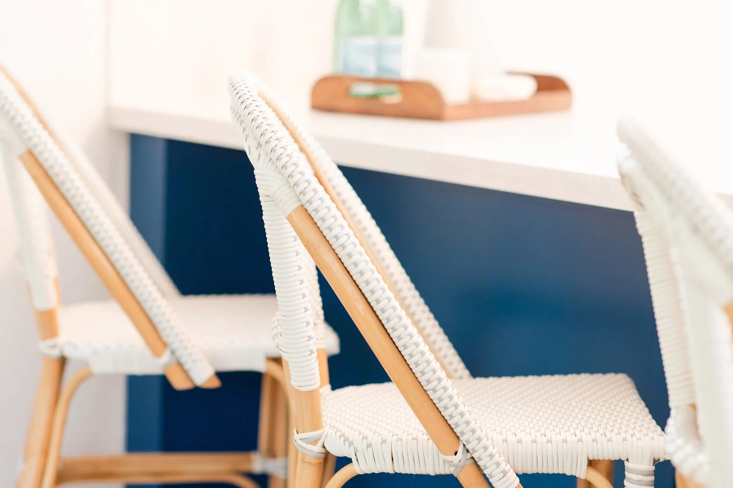 White counter stools at a navy island