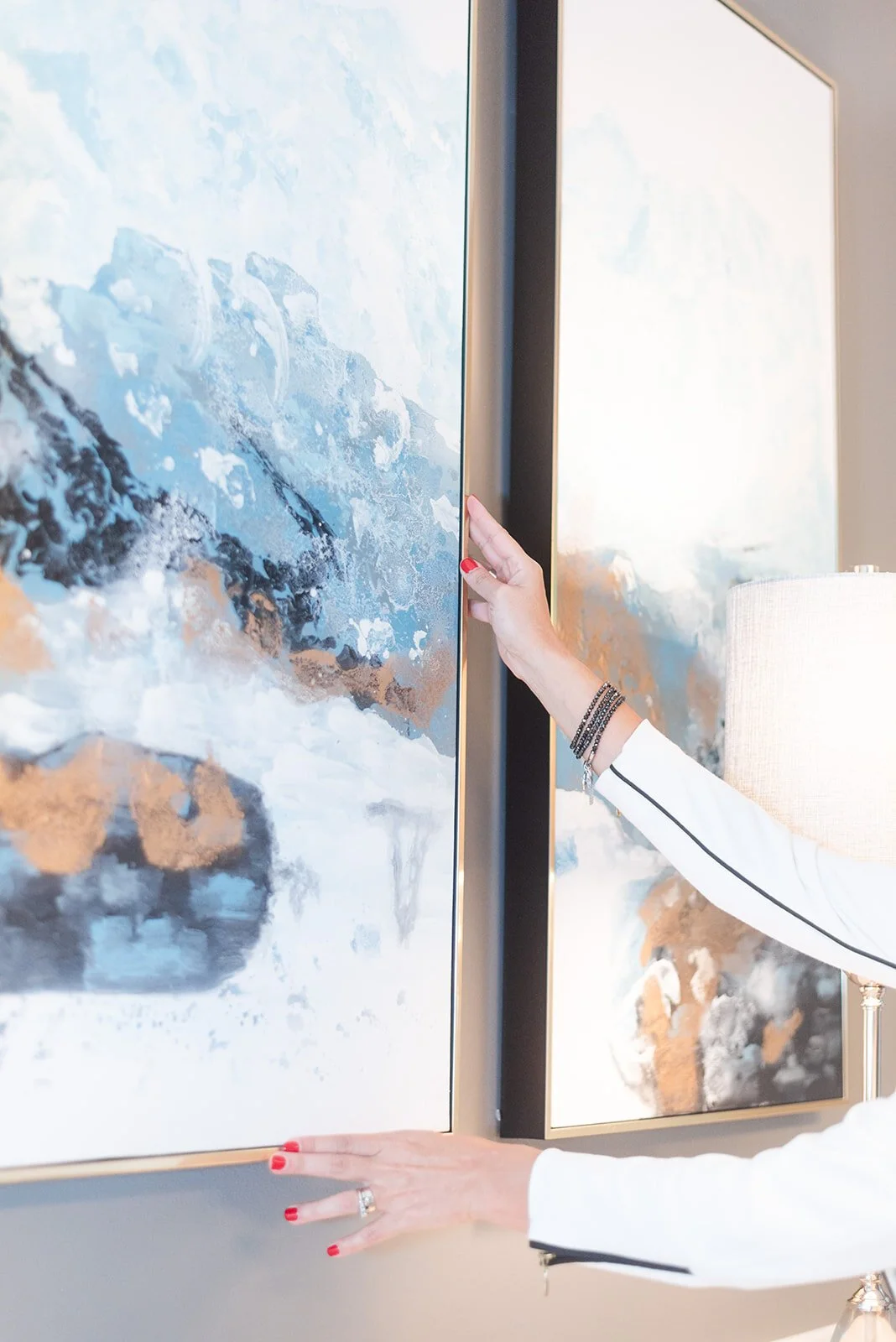 Hand adjusting a blue abstract painting