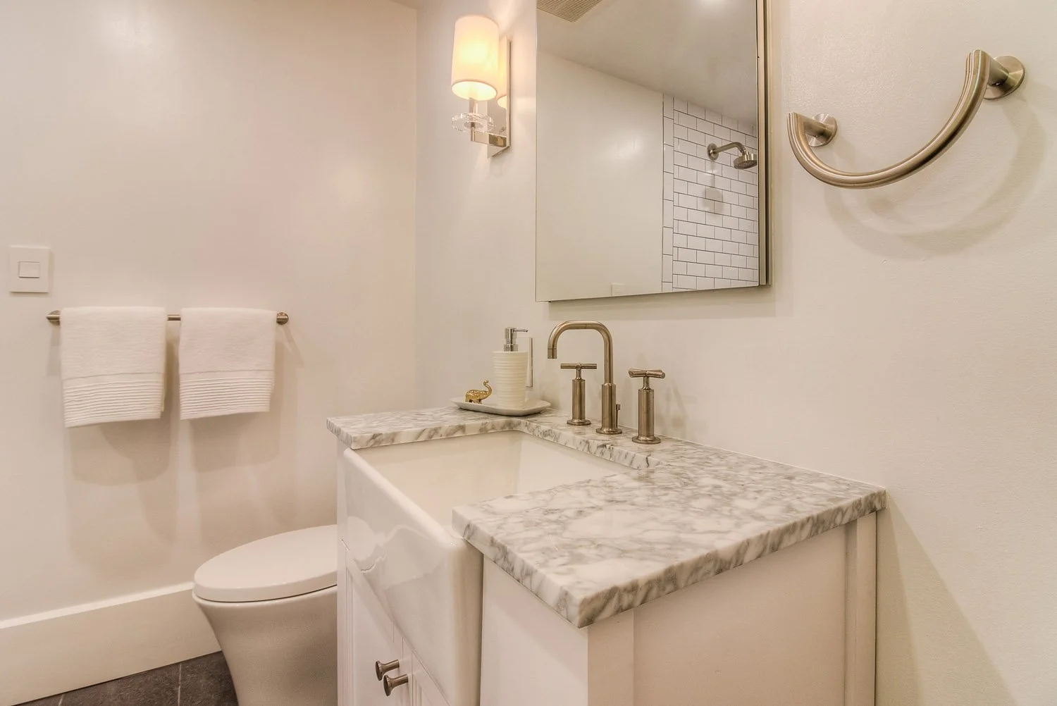 Marble-top vanity with black framed mirror and towel ring