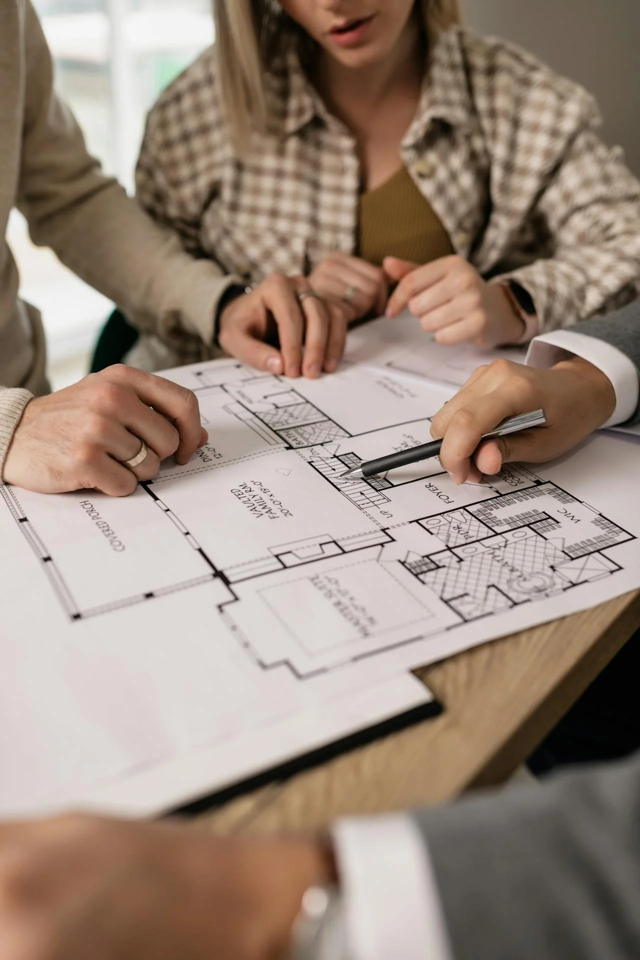 People reviewing architectural floor plans at a table