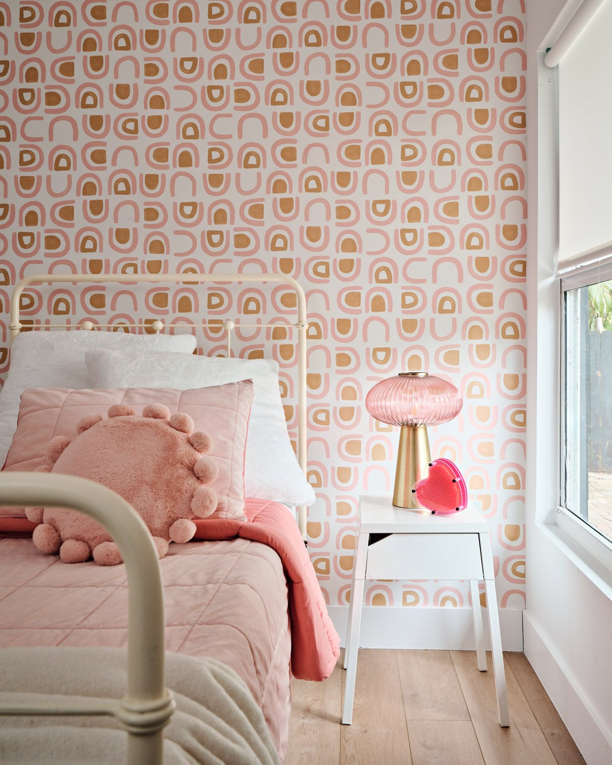 Girls bedroom with pink bedding, floral wallpaper and mushroom lamp