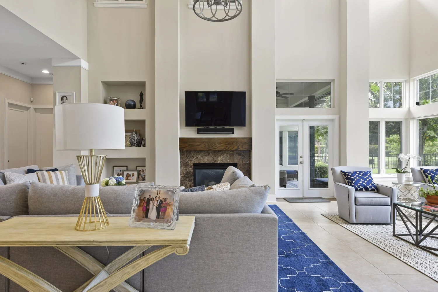Great room with sectional, console table and fireplace with TV