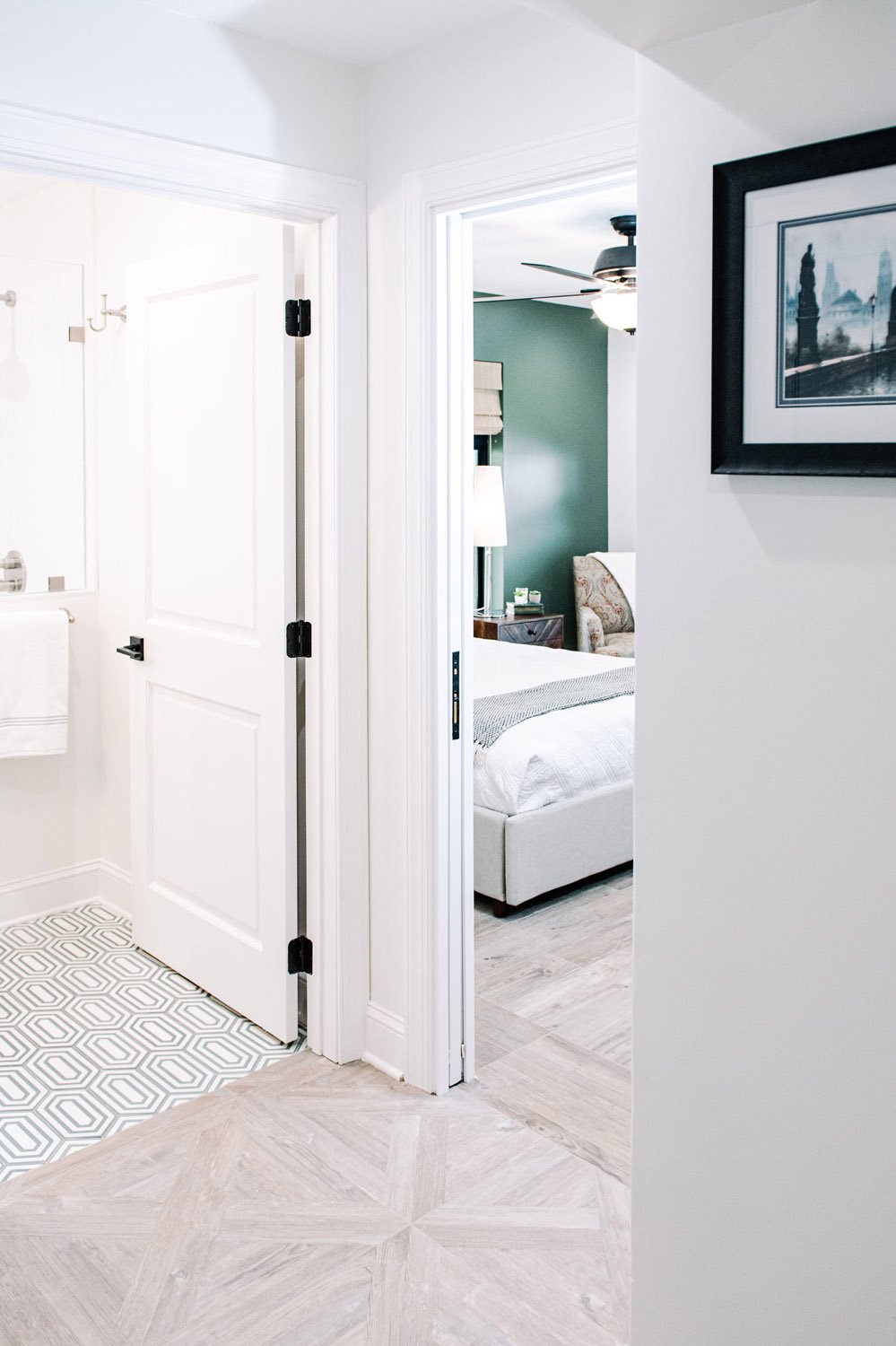 Hallway with herringbone wood floor leading to a bedroom