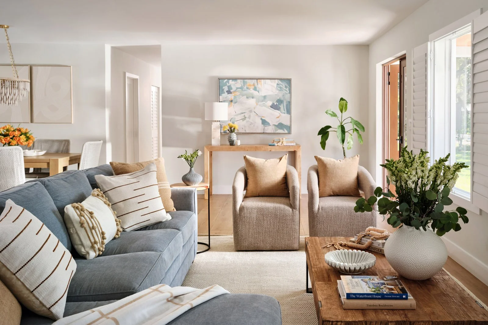 Living room with blue sofa, neutral armchairs and wood coffee table