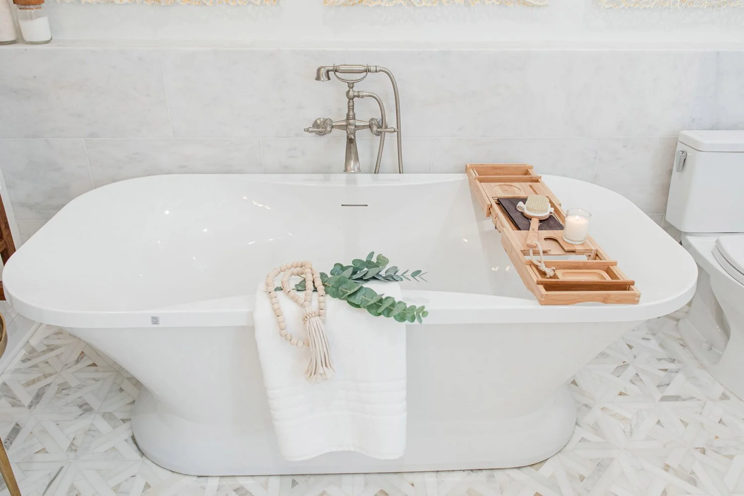 Freestanding tub with wood bath caddy and greenery