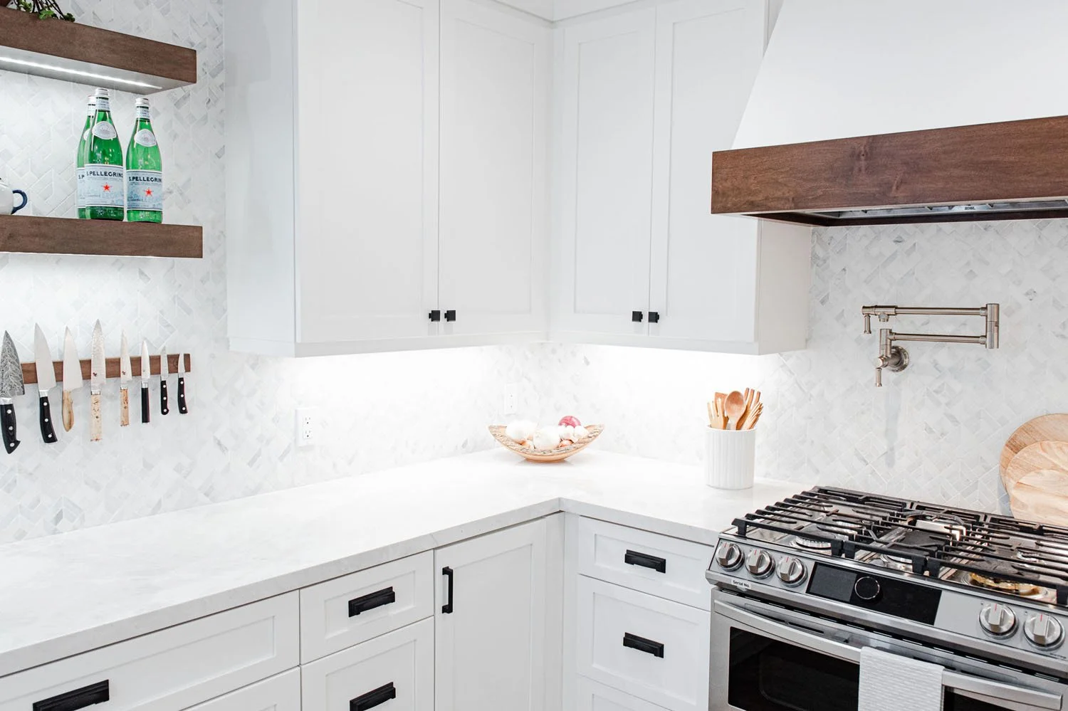 Range wall with walnut hood band and floating shelves