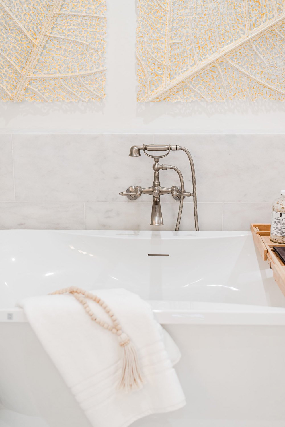 White freestanding tub with floor-mounted faucet and white towel