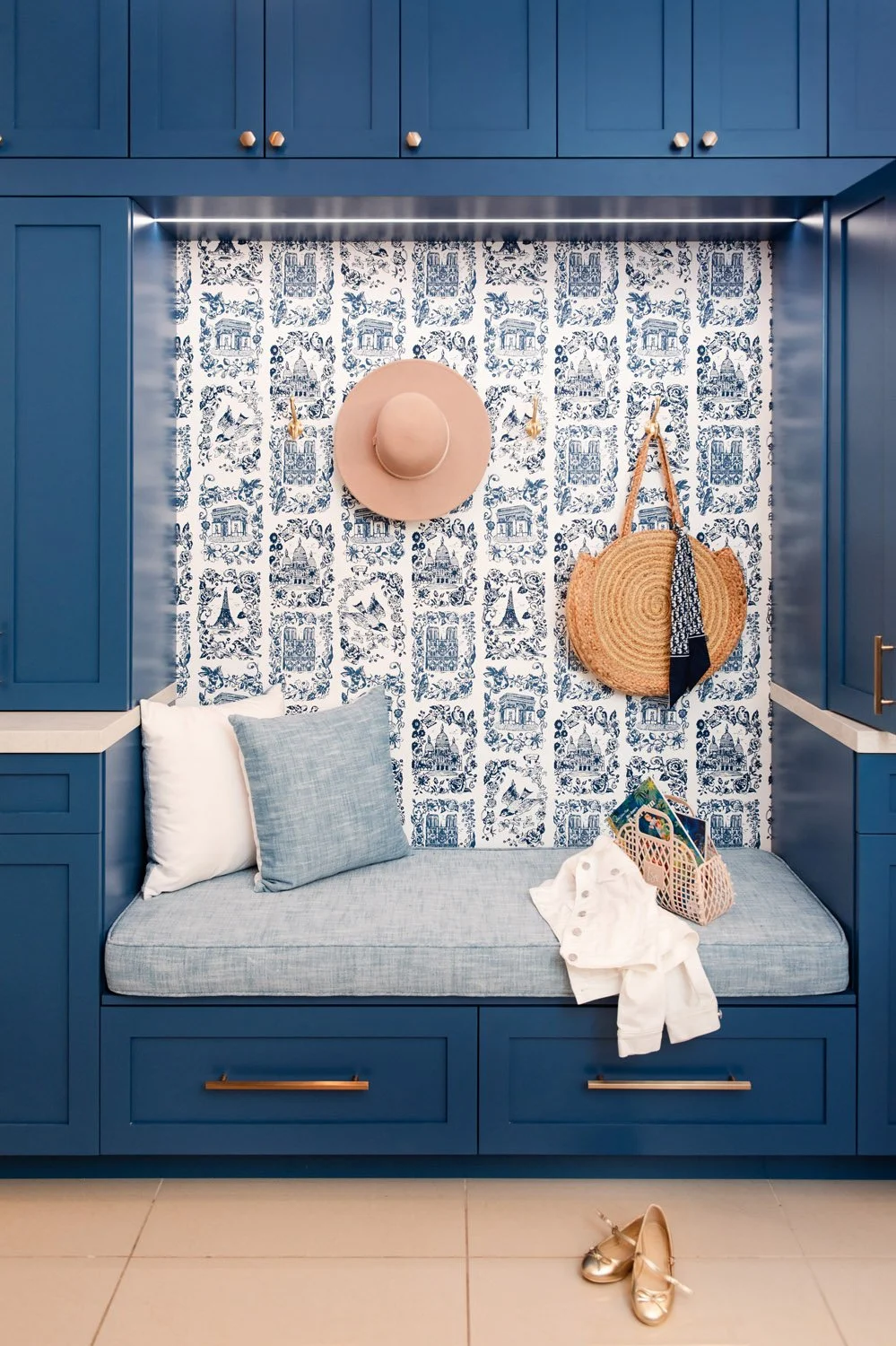 Navy built-in bench nook with blue patterned tile and hooks