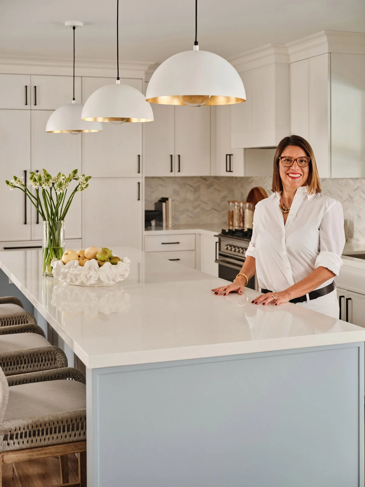 Interior designer Adriana Jacir at a kitchen island with dome pendants