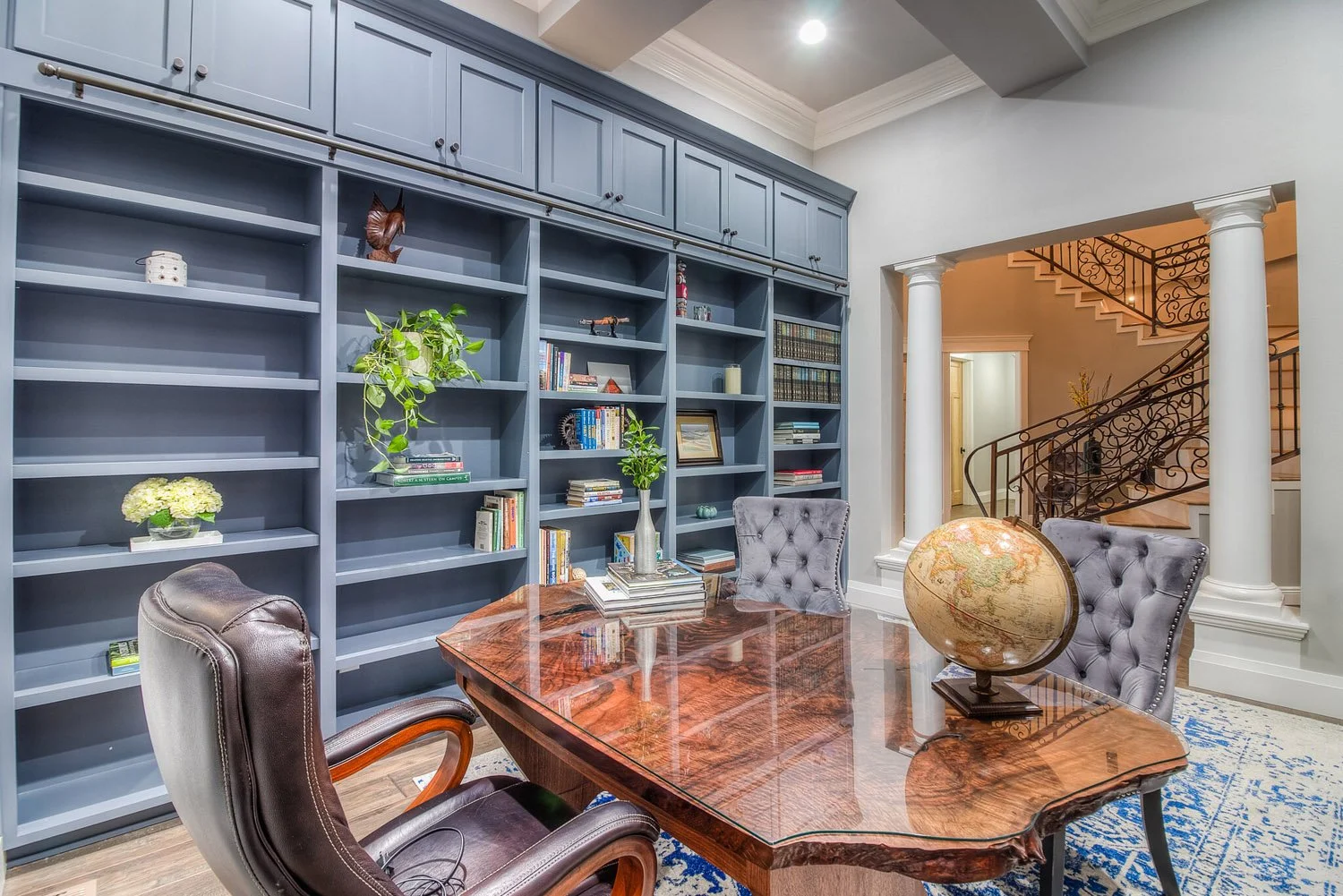 Library office with navy built-in bookshelves and wood desk