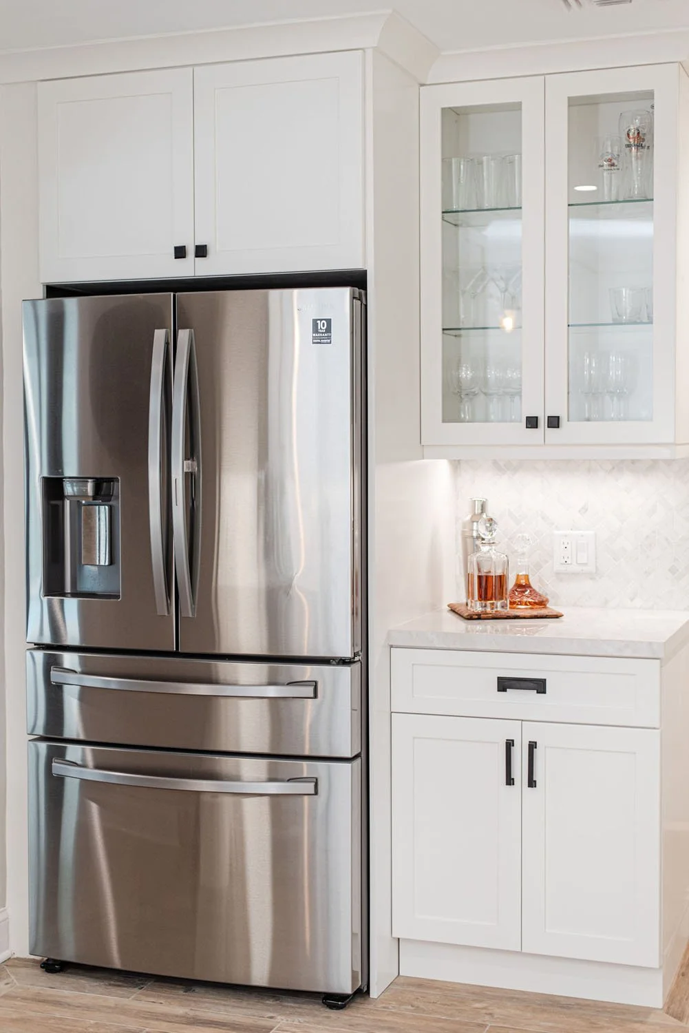 Stainless French door refrigerator with glass-front cabinets