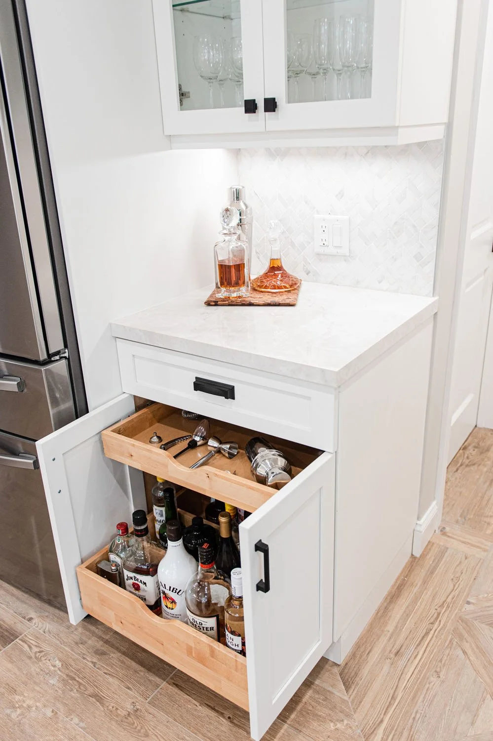 Pull-out drawer with bottles under a white counter