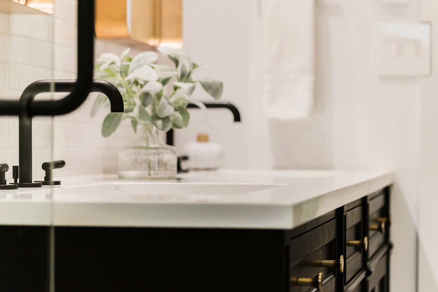 Black vanity with matte black faucet and white countertop
