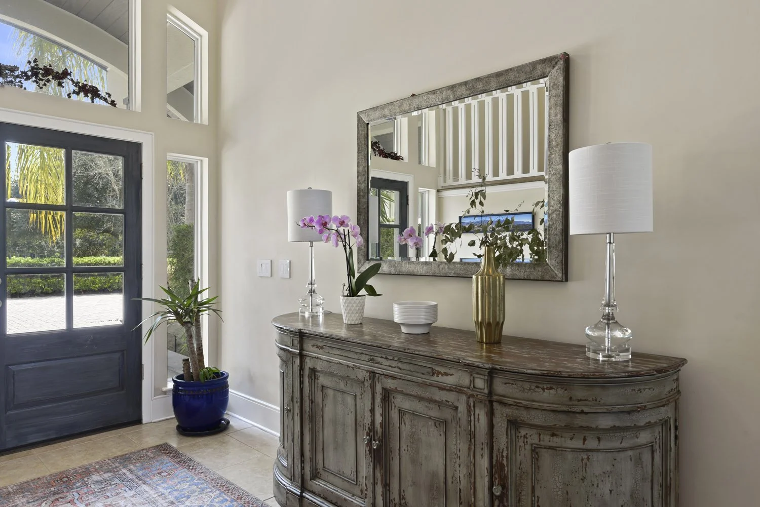 Distressed wood console with mirror, table lamps and orchid