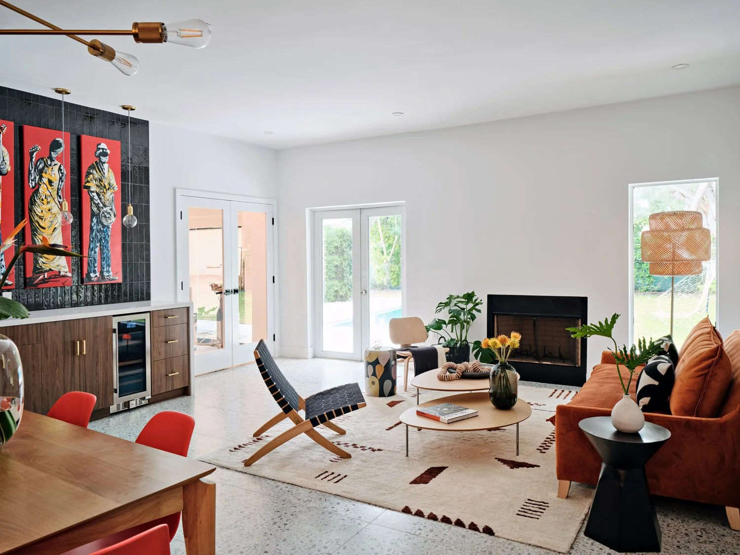 Living room with orange chair, black sling chair and red framed artwork