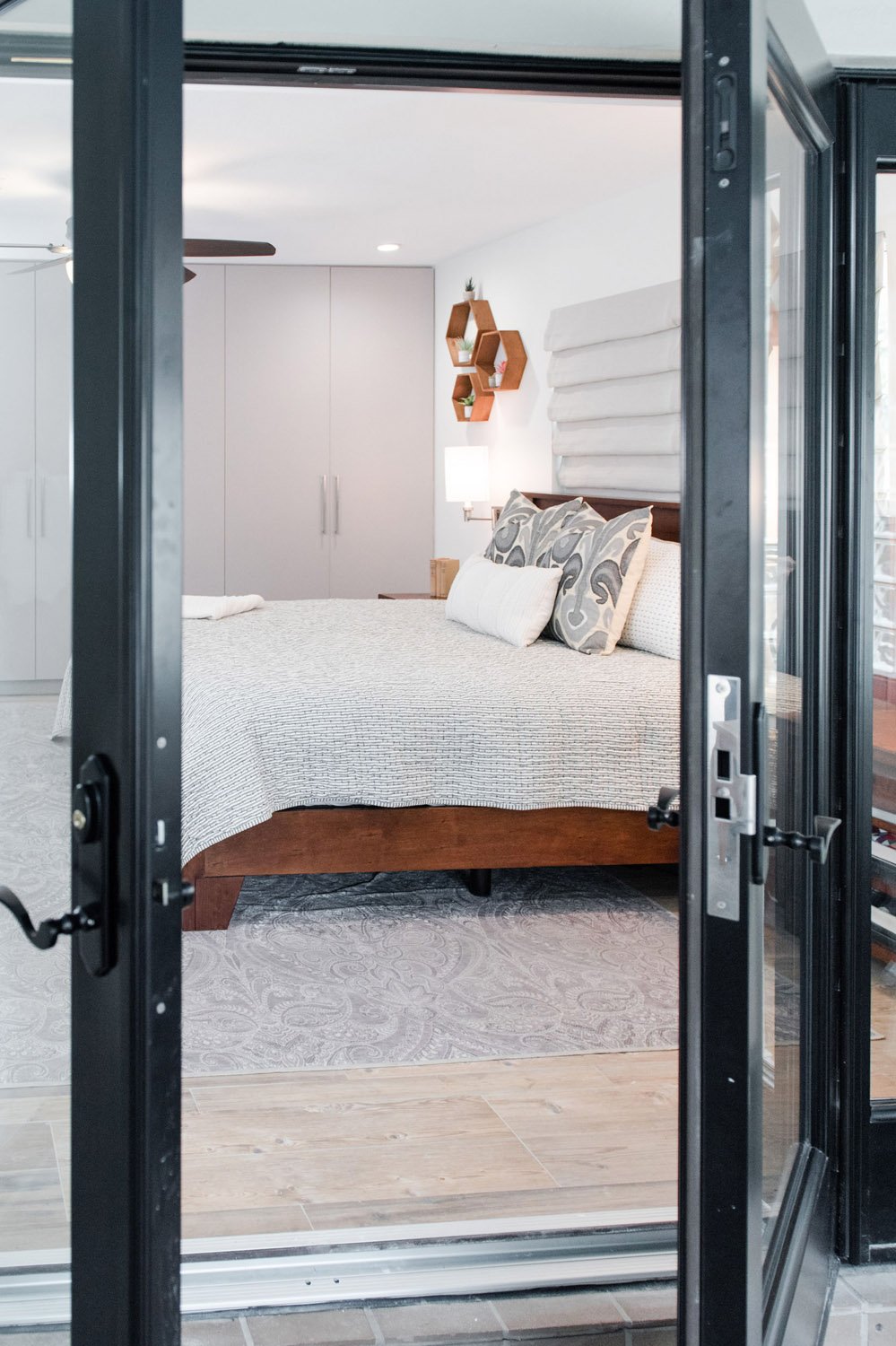 Black French doors opening to a bedroom