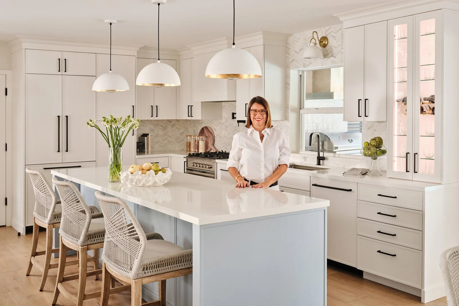 Interior designer Adriana Jacir standing at a white kitchen island