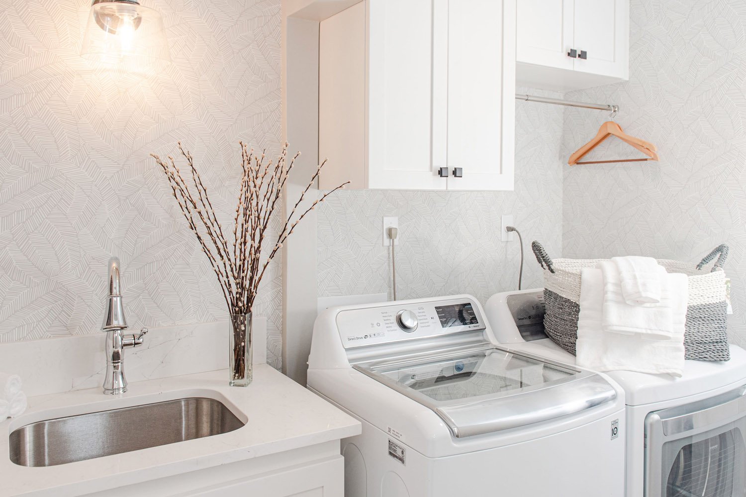Laundry room with utility sink, washer and decorative branches
