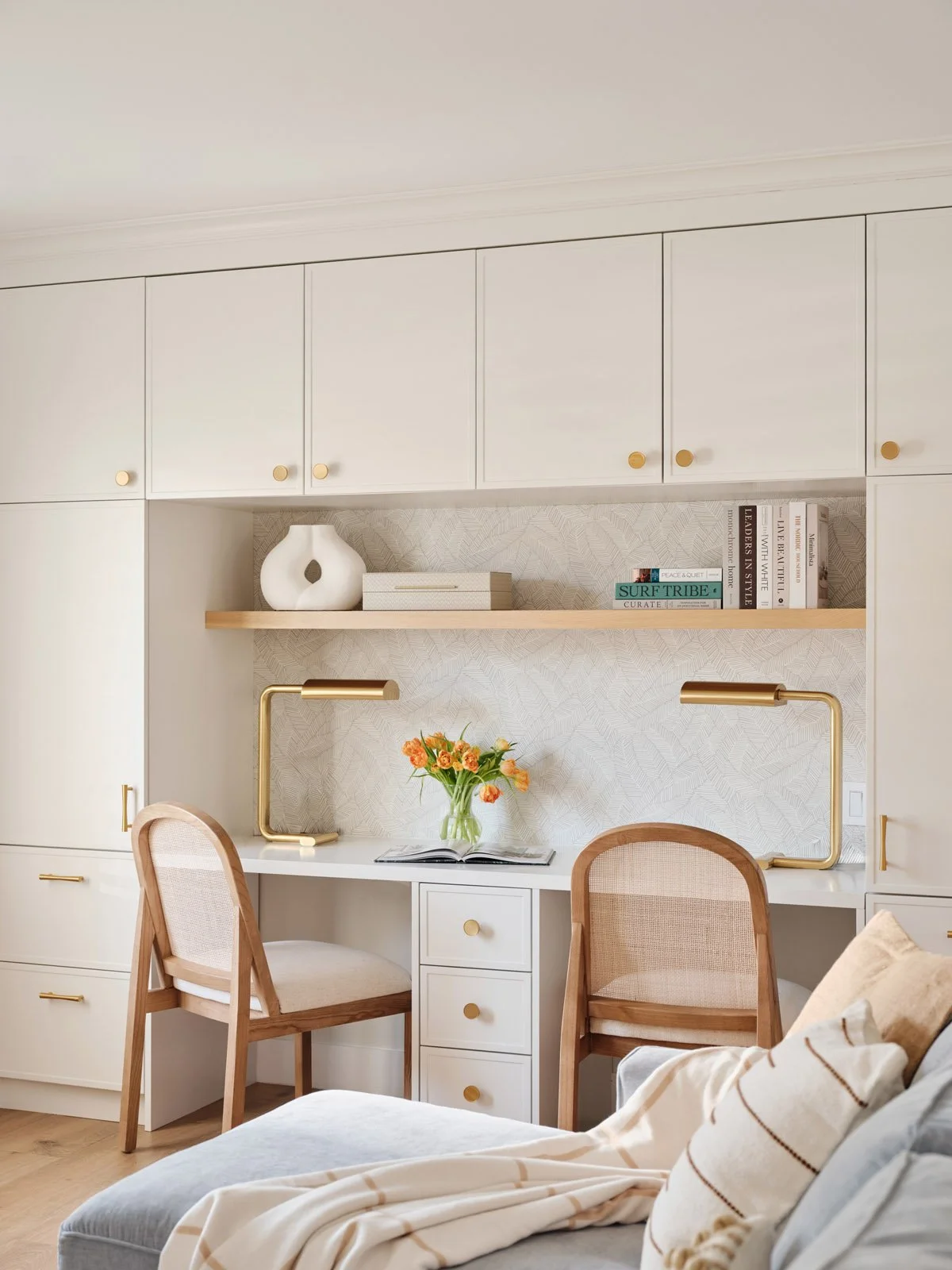 Home office built-ins with two cane chairs and open shelves