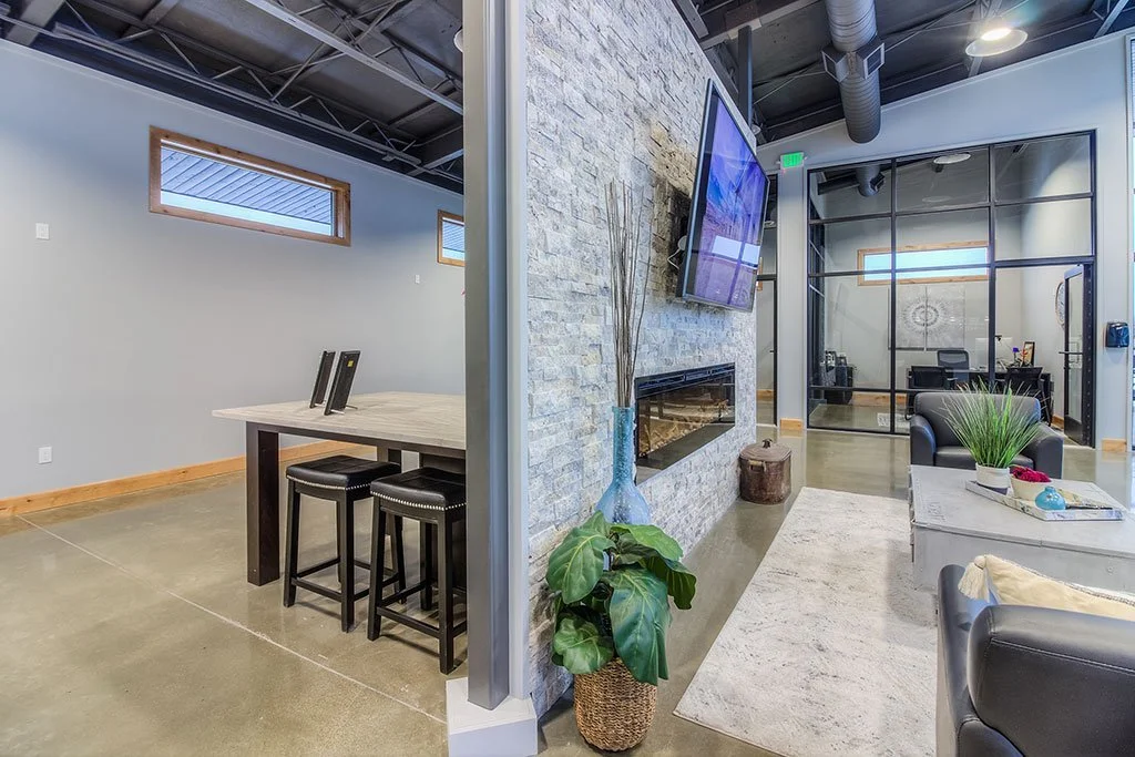 Lounge with stone fireplace, bar counter and glass offices