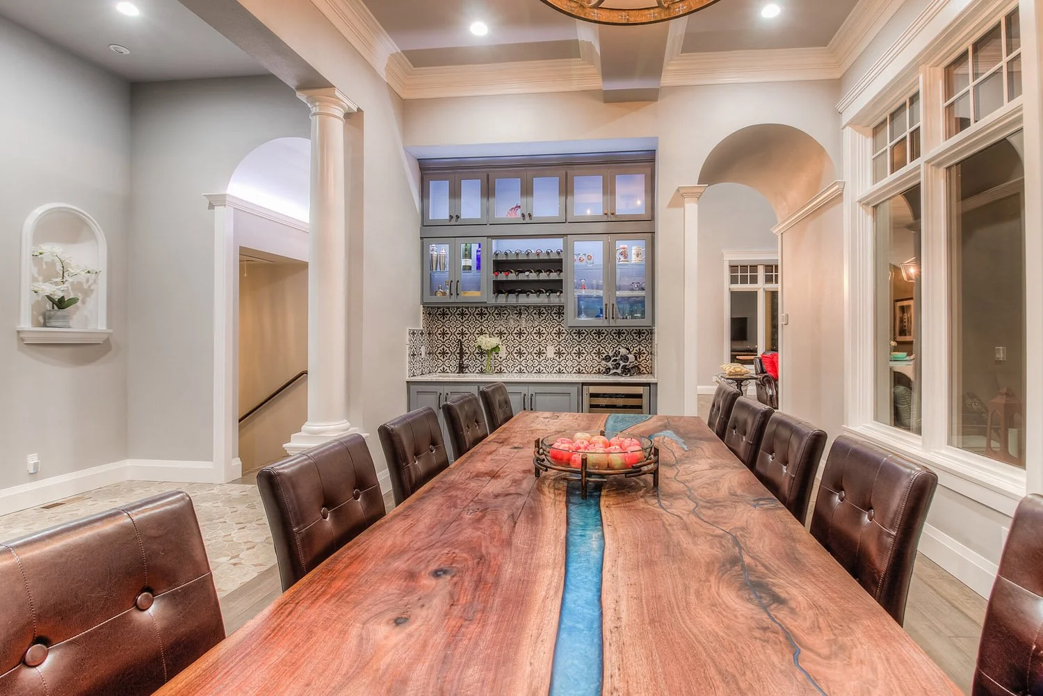 Live-edge dining table with blue resin inlay and leather chairs