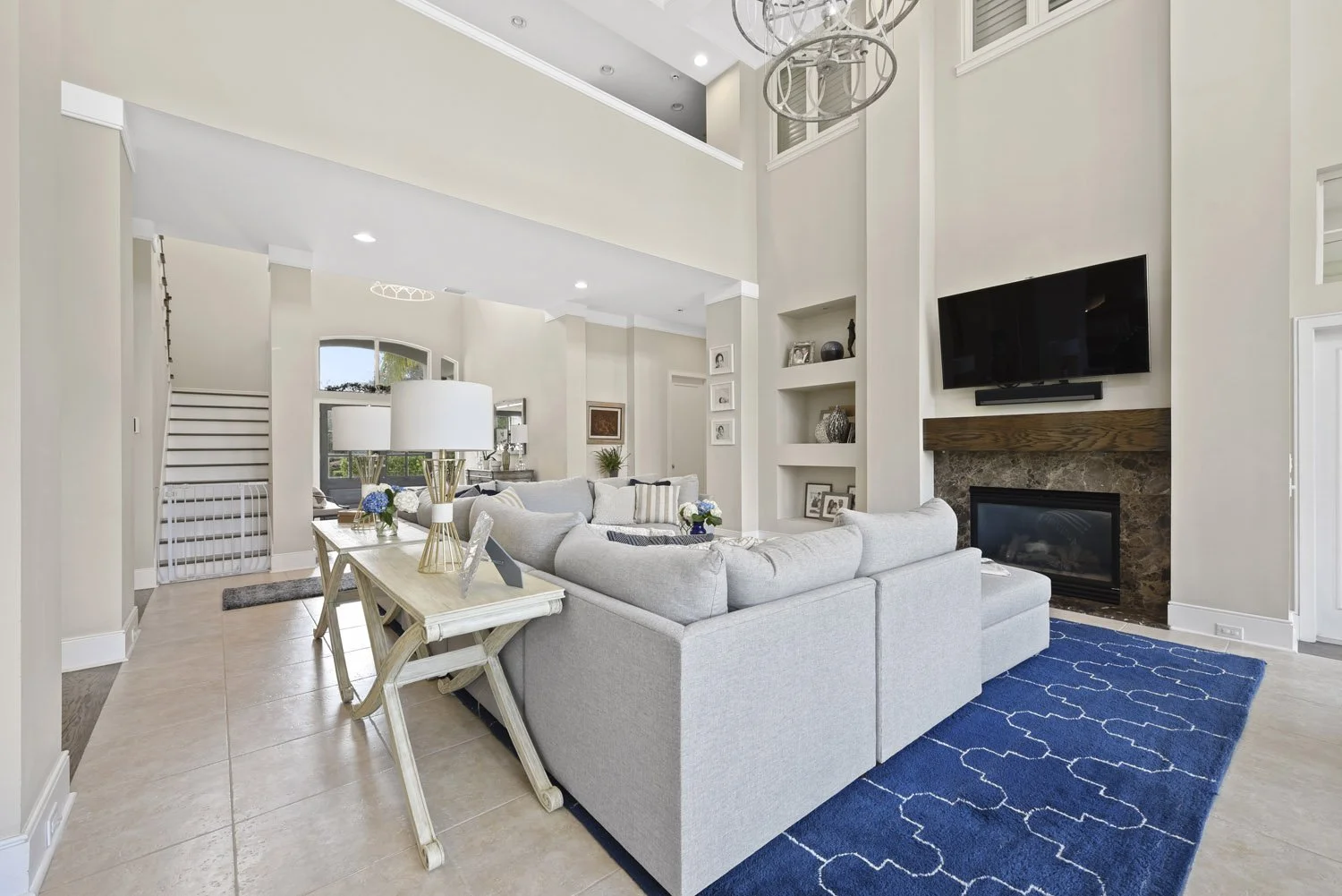 Gray sectional facing a stone fireplace with wall-mounted TV