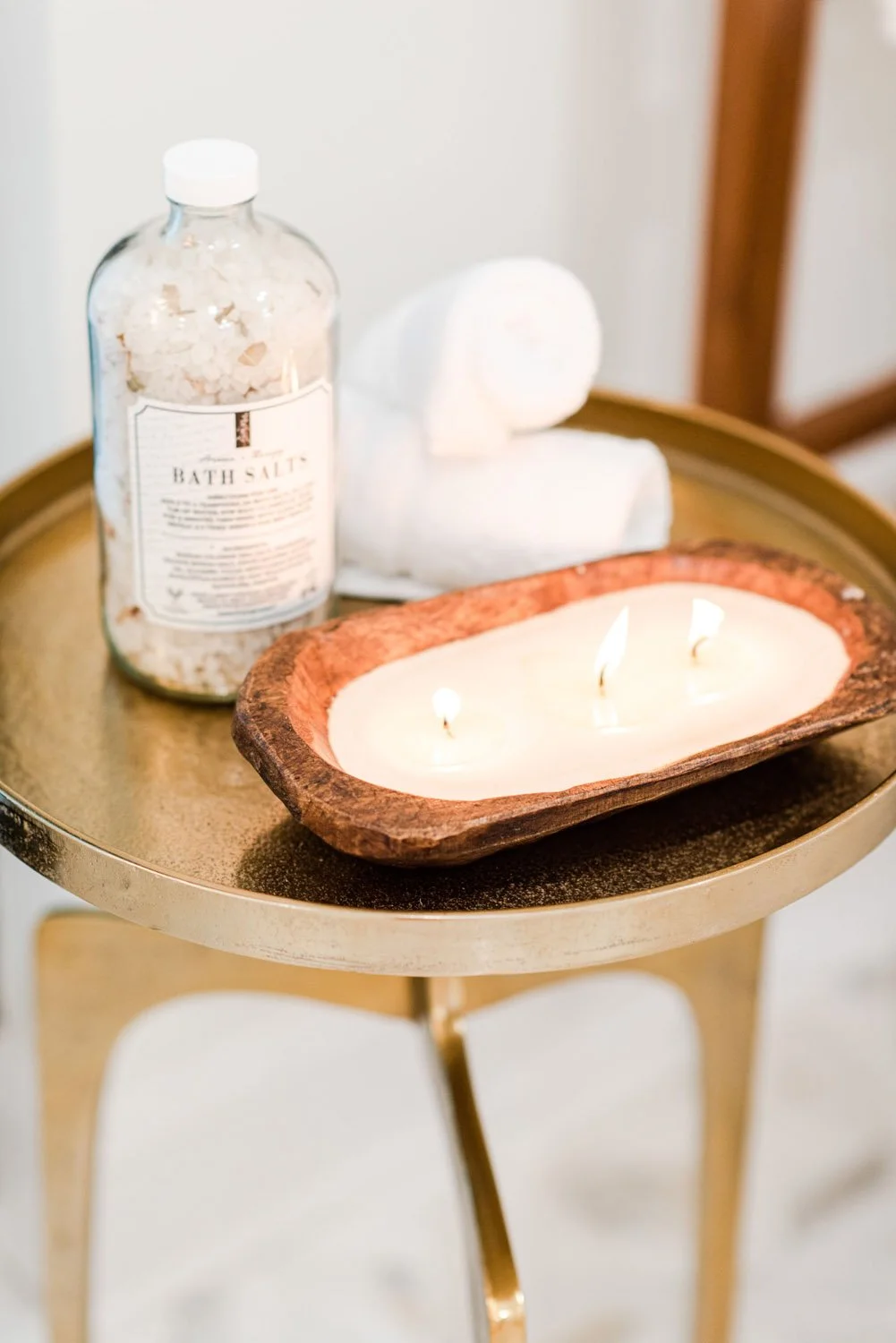 Gold side table with bath salts and wood bowl