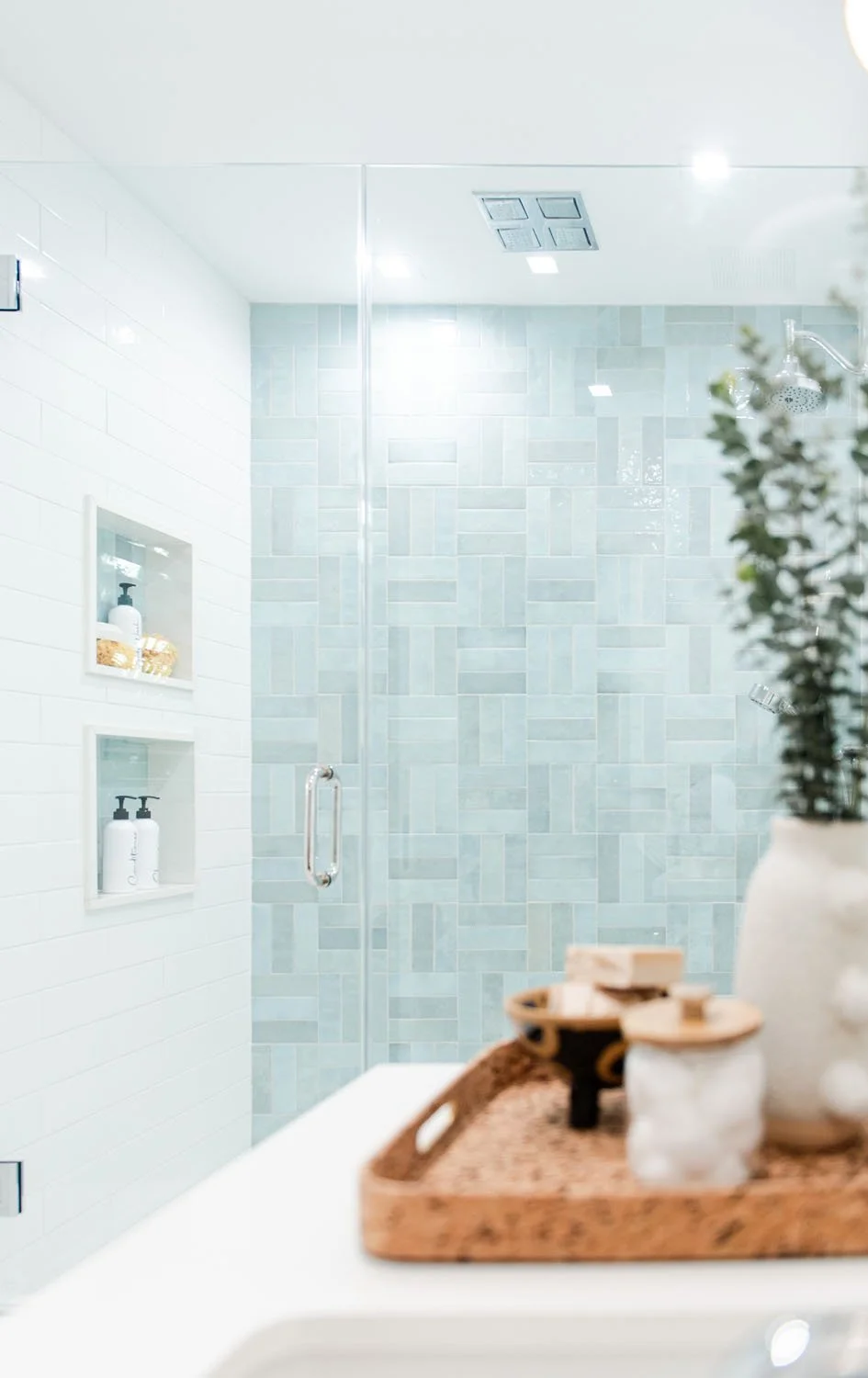 Shower with green herringbone tile and built-in niche