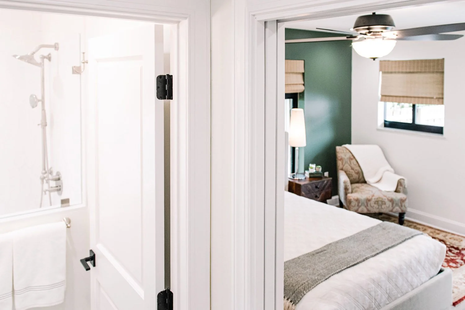 Bathroom doorway with view into a bedroom with sage green wall